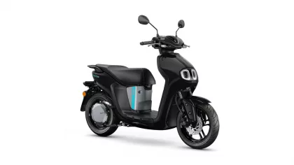 Black electric scooter shown in a right-side profile, with a teal accent panel and dual front lights on a white background.