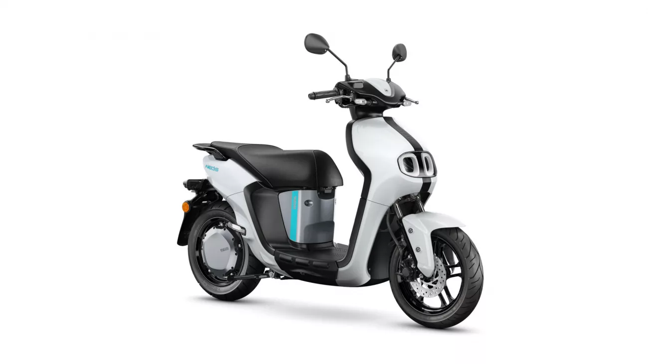 White and black scooter shown from a side angle with turquoise accent stripe on the body and large wheels.