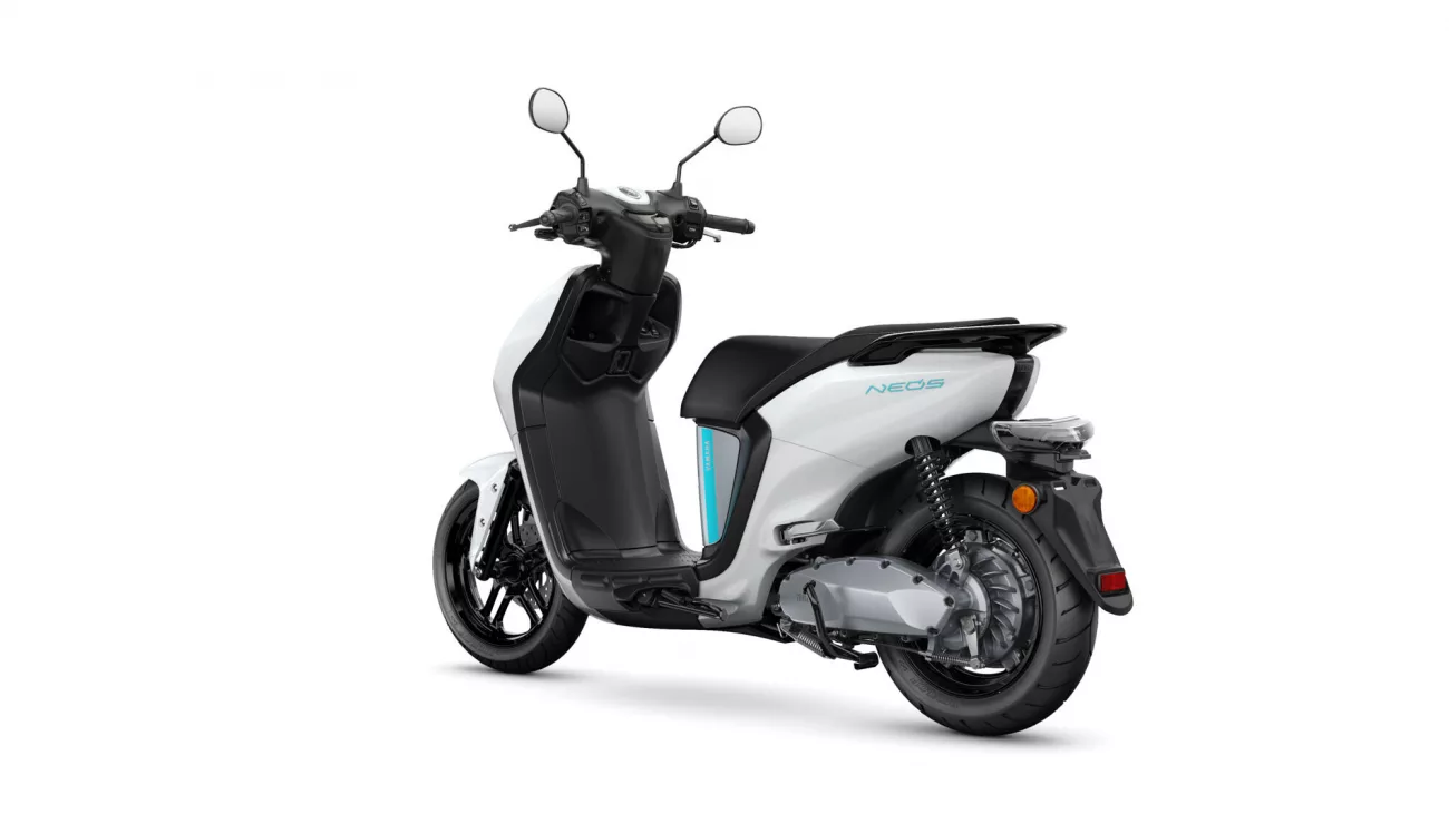 White and black scooter from a rear-side angle, showing the seat, body panels, and rear wheel.