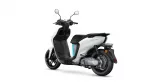 White and black scooter from a rear-side angle, showing the seat, body panels, and rear wheel.
