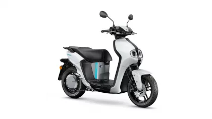 White and black modern scooter photographed from the front-right side, showing the handlebars and mirrors.