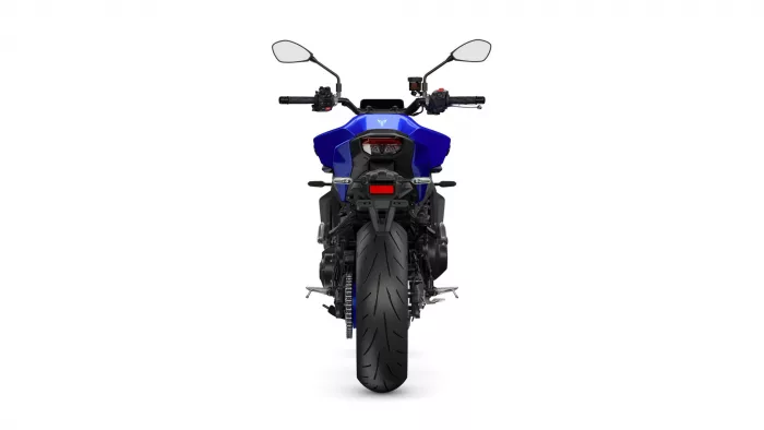 Rear view of a blue sport motorcycle, showing the wide rear tire, taillight, and handlebar mirrors.