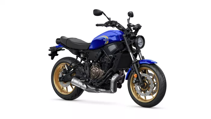 Blue Yamaha motorcycle with gold rims, shown from the left side, outdoors against a white background