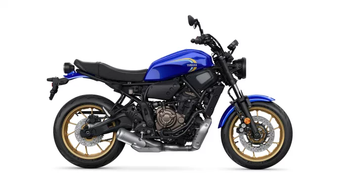 Blue Yamaha street motorcycle shown in side view with gold wheels and black frame