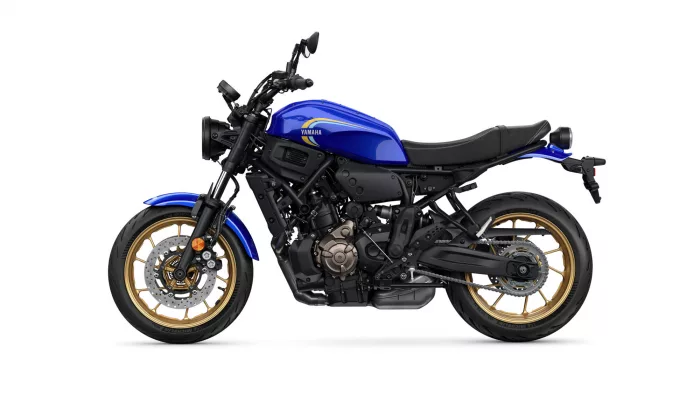 Side profile of a blue Yamaha sport motorcycle with gold wheels on a white background, showing the engine and frame details