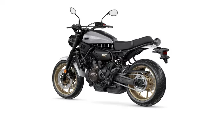Side view of a Yamaha XSR700 motorcycle with a silver fuel tank, black frame, and gold wheels photographed against a white background.