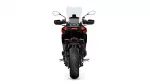 Rear view of a red and black adventure motorcycle with a tall windshield and wide rear tire.
