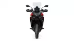 Front view of a red-and-black sport motorcycle with a tall windscreen, mirrors, and dual headlights facing forward.