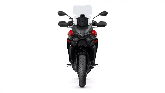 Front view of a red-and-black sport motorcycle with a tall windscreen, mirrors, and dual headlights facing forward.