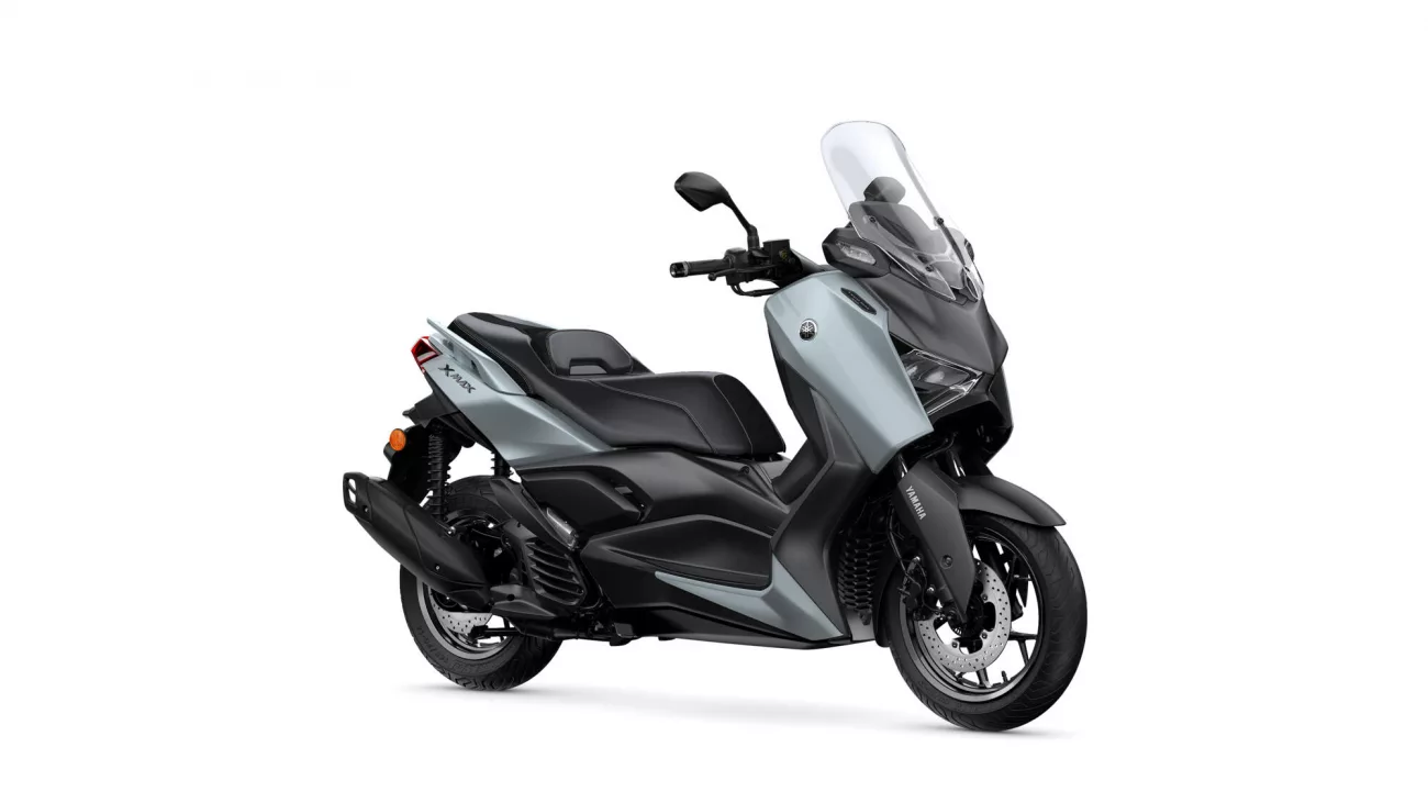 Side view of a silver and black Yamaha scooter with a tall windshield, shown facing right.