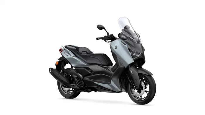 Side view of a silver and black Yamaha scooter with a tall windshield, shown facing right.