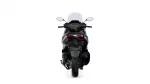 Rear view of a black sport motorcycle with a tall windshield and red taillights against a white background