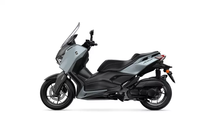 Grey and black Yamaha XMAX scooter shown in side view on a white background, front wheel and exhaust visible.
