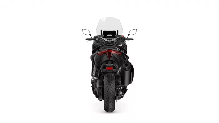 Rear view of a black sport motorcycle, showing the red tail light, rear wheel, and exhaust system.