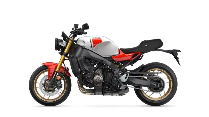 Side view of a white and red Yamaha XSR900 motorcycle with gold front forks and exposed engine styling on a white background.
