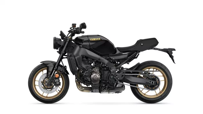 Side view of a black Yamaha motorcycle with gold rims, exposing engine and exhaust (XSR900).