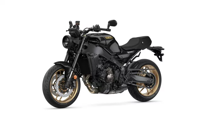 Black Yamaha XSR900 sport motorcycle in a three-quarter front-left view against a white background, showing gold wheels and detailed mechanics.