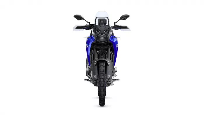 Front view of a blue adventure motorcycle with a tall windshield and dual-sport tires visible from the front.