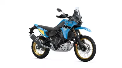 Blue Yamaha adventure motorcycle shown in a three-quarter front view, with gold rims and off-road tires, and a tall windscreen.