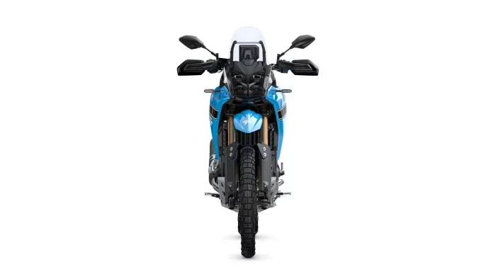 Front view of a blue adventure motorcycle with a tall windshield and knobby tires, facing the camera.