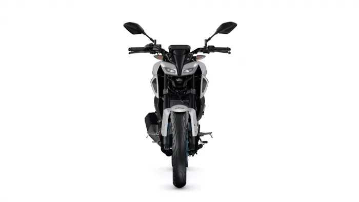 Front view of a white and black sport motorcycle facing the camera, headlights centered.