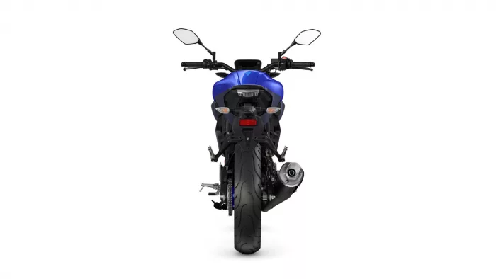 Rear view of a blue sport motorcycle on a white background, showing taillight, rear tire, and exhaust area.