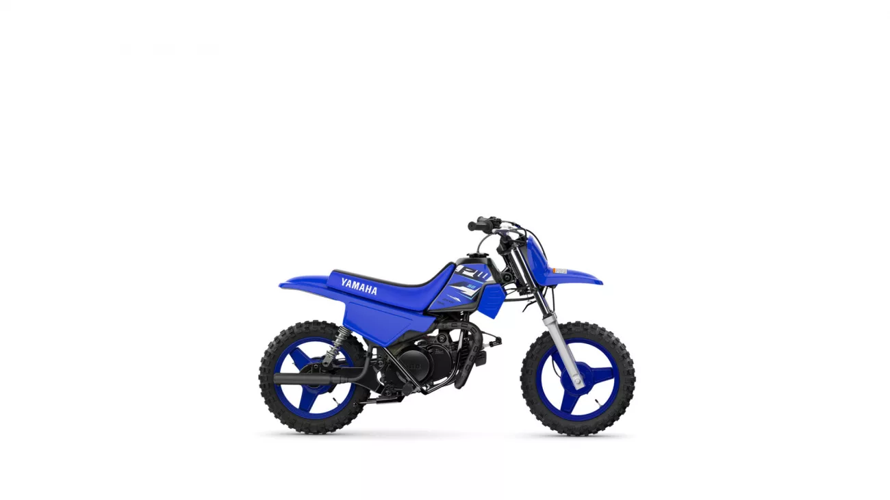 Blue Yamaha dirt bike side view with knobby tires on a white background and studio lighting