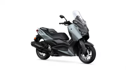 Silver-gray Yamaha XMAX scooter with a tall clear windshield and black accents, shown in a side view.