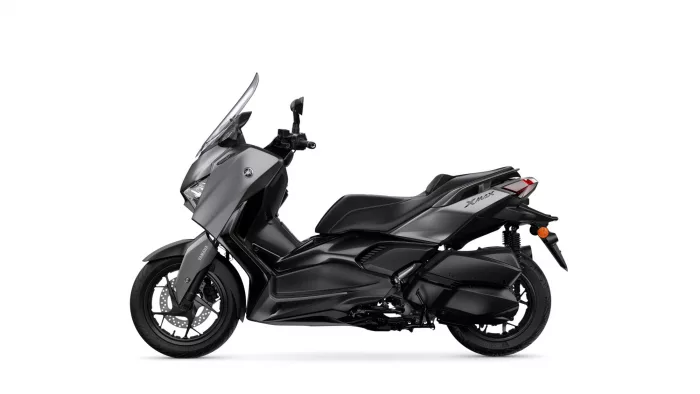 Side view of a gray and black Yamaha Tmax sport-tourer motorcycle, showing its sleek fairing and windshield