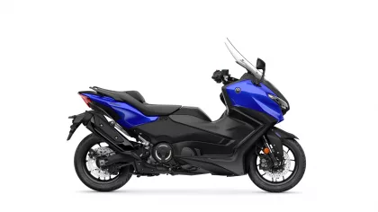Side view of a blue and black Yamaha sport motorcycle with a tall windshield sun visor on a white background