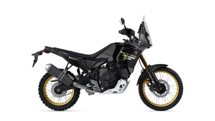 Side view of a black Yamaha Tenere 700 World Raid adventure motorcycle with gold wheels and tall windscreen