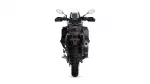 Rear view of a black adventure motorcycle, showing the wide rear tire, taillight, and exhaust.