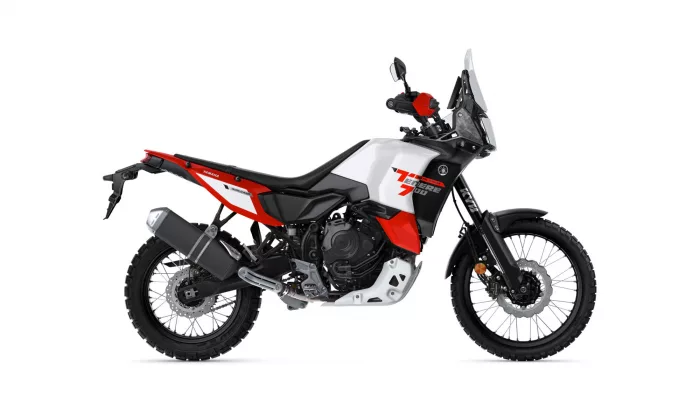 White and red Yamaha Tenere 700 adventure motorcycle shown in side profile with knobby tires and tall windscreen.