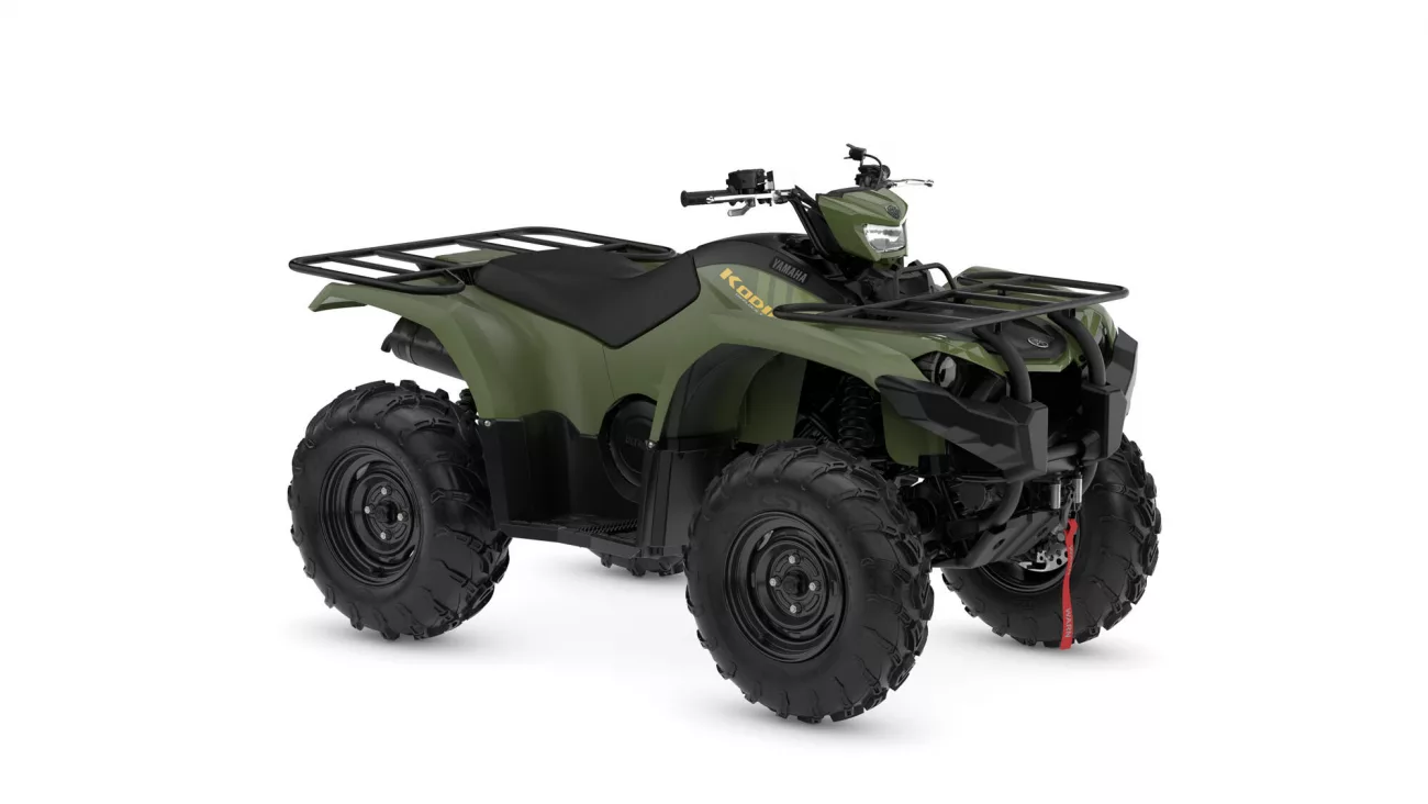 Olive-green all-terrain vehicle (ATV) with front and rear cargo racks and large knobby tires.