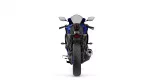 Rear view of a blue sport motorcycle on a white background, showing taillight, exhaust, and wide rear tire.