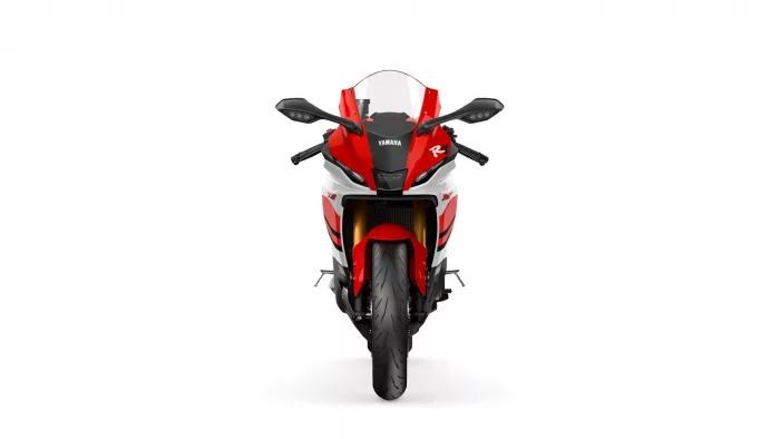 Front view of a red and white Yamaha R1 sport motorcycle with windshield and prominent headlight area.