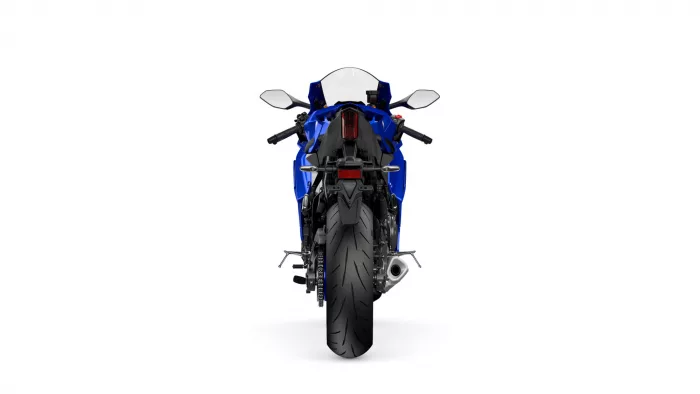 Rear view of a blue sport motorcycle with wide rear tire, taillight, and dual mirrors against a white background, showcasing the bike's stance.