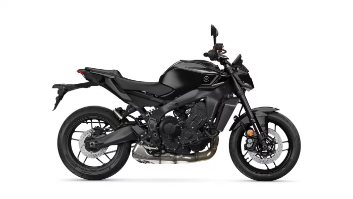 Black sport motorcycle in side view, showcasing its sleek matte-black body and exposed engine details.
