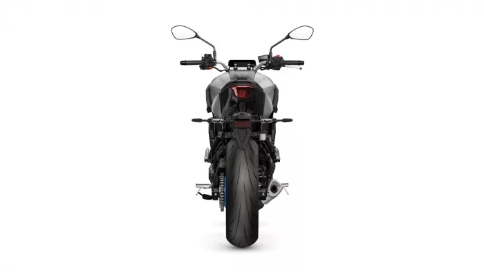 Rear view of a gray sport motorcycle showing the tail light, rear fender, and wide rear tire with mirrors and handlebars visible above.