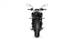 Rear view of a black sport motorcycle with a red taillight and wide rear tire, facing away from the viewer