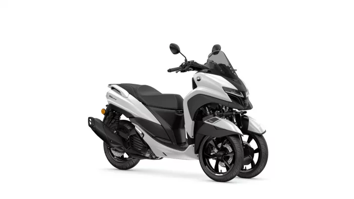 White and black Yamaha Tricity scooter with windshield, side view against a white background