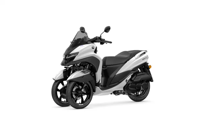 White Yamaha Tricity scooter with twin front wheels, windshield, and black seat seen from a front-side angle, on a white background.