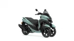 Teal Yamaha three‑wheel scooter with a black seat and clear windshield, angled front view