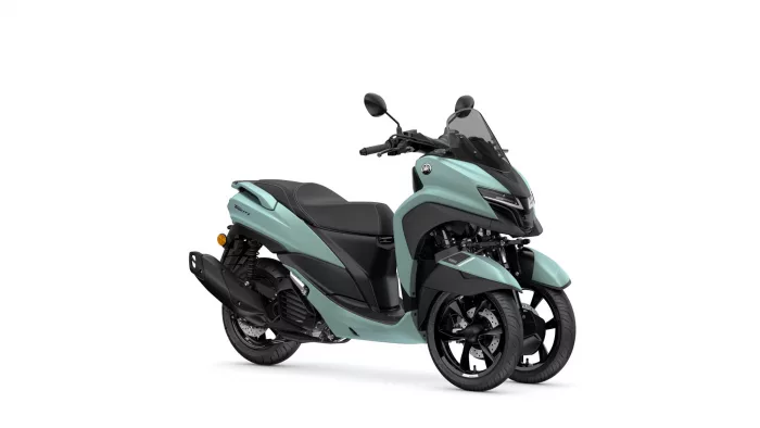Teal Yamaha three‑wheel scooter with a black seat and clear windshield, angled front view