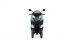 Front view of a teal motorcycle with a dark windshield and handlebars, facing the viewer.
