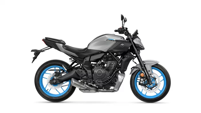 Side view of a gray Yamaha MT-07 motorcycle with bright blue rims against a white background, showing the engine and exhaust detail responsibly visible