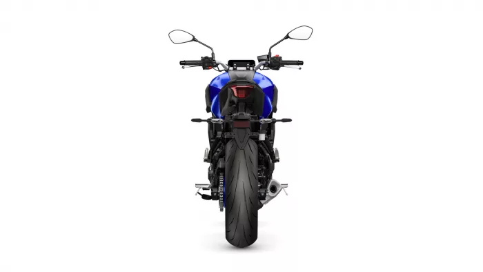 Rear view of a blue sport motorcycle on a white background, showing the taillight and wide rear tire.