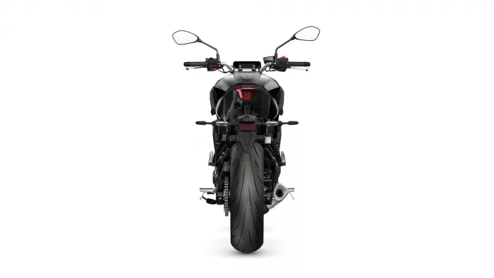 Rear view of a black sport motorcycle centered on a white background, showing taillight, exhaust, and rear tire