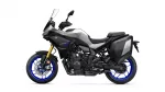 Side view of a Yamaha Tracer 7 GT sport-touring motorcycle with black-gray body, blue wheels, and hard panniers on both sides.