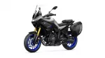 Yamaha Tracer 9 GT sport-touring motorcycle with a tall windshield, black-gray body, and blue alloy wheels with side panniers (left-side view).